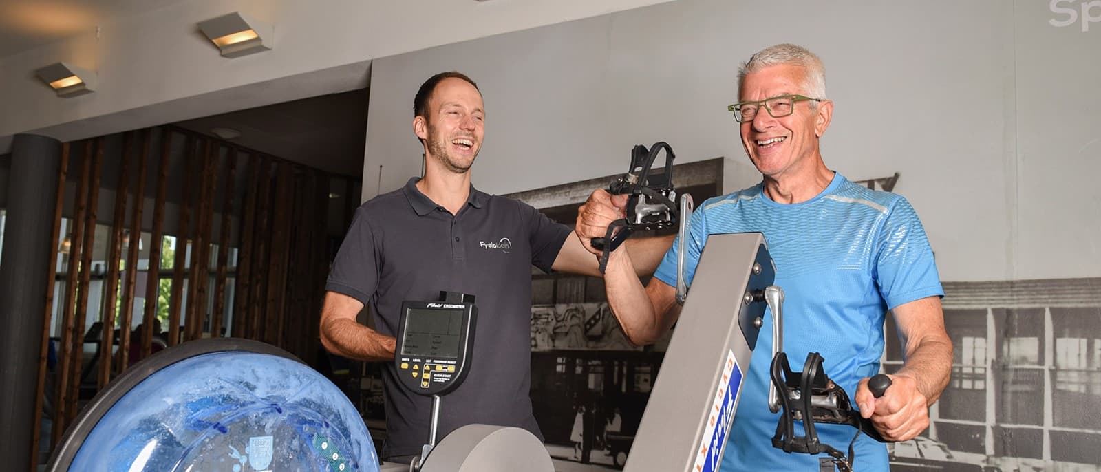 Fysiotherapeut die deelnemer aan het begeleiden en motiveren is bij de handbike